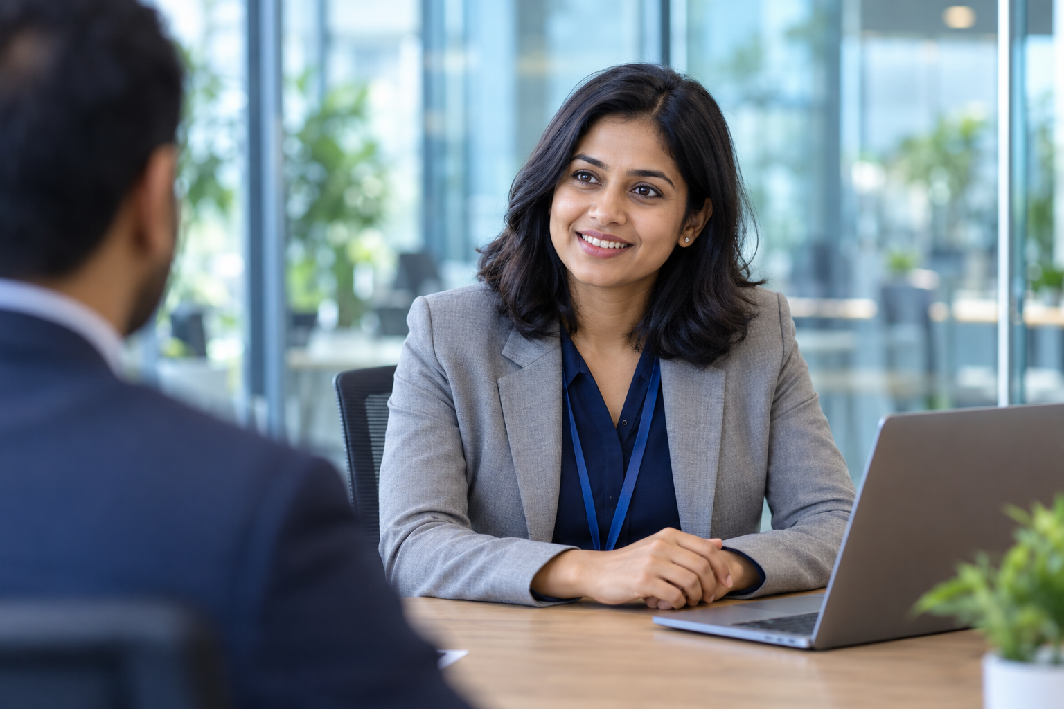 Illustrative candidate discussing an opportunity with an interviewer in a modern office.